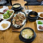 봄철 백반집 식탁에 된장빛 쑥국과 밥·반찬이 놓인 모습