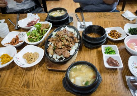 봄철 백반집 식탁에 된장빛 쑥국과 밥·반찬이 놓인 모습