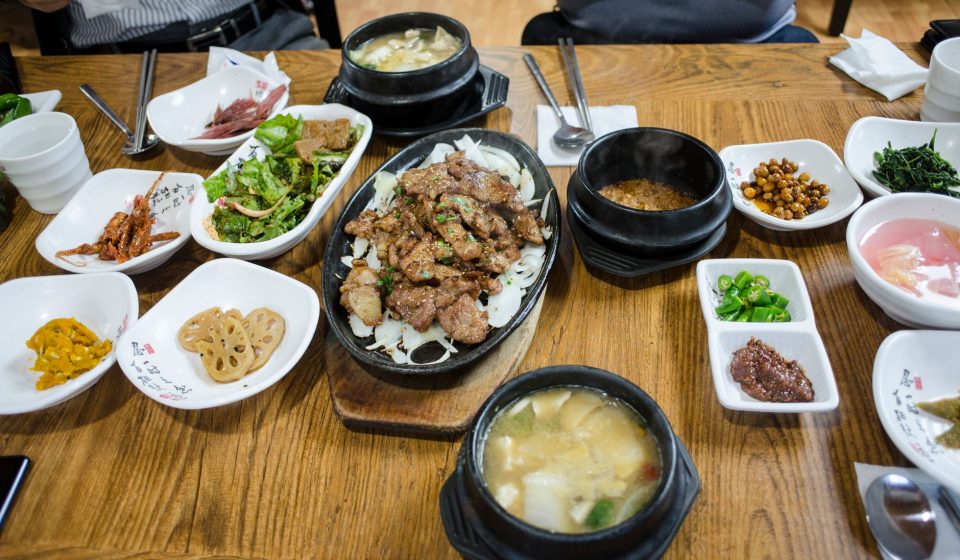 봄철 백반집 식탁에 된장빛 쑥국과 밥·반찬이 놓인 모습