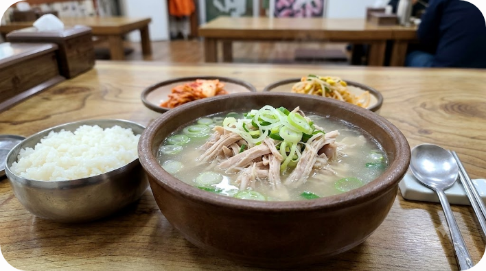 찢은 닭고기와 대파가 담긴 닭곰탕과 공깃밥 상차림