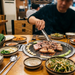 삼겹살 이름 뜻 고깃집 불판 위에서 삼겹살을 굽는 식탁 풍경