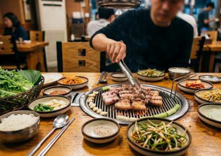 삼겹살 이름 뜻 고깃집 불판 위에서 삼겹살을 굽는 식탁 풍경